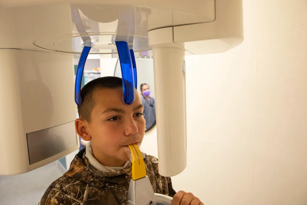 Modern panoramic dental X-ray machine in operation.
