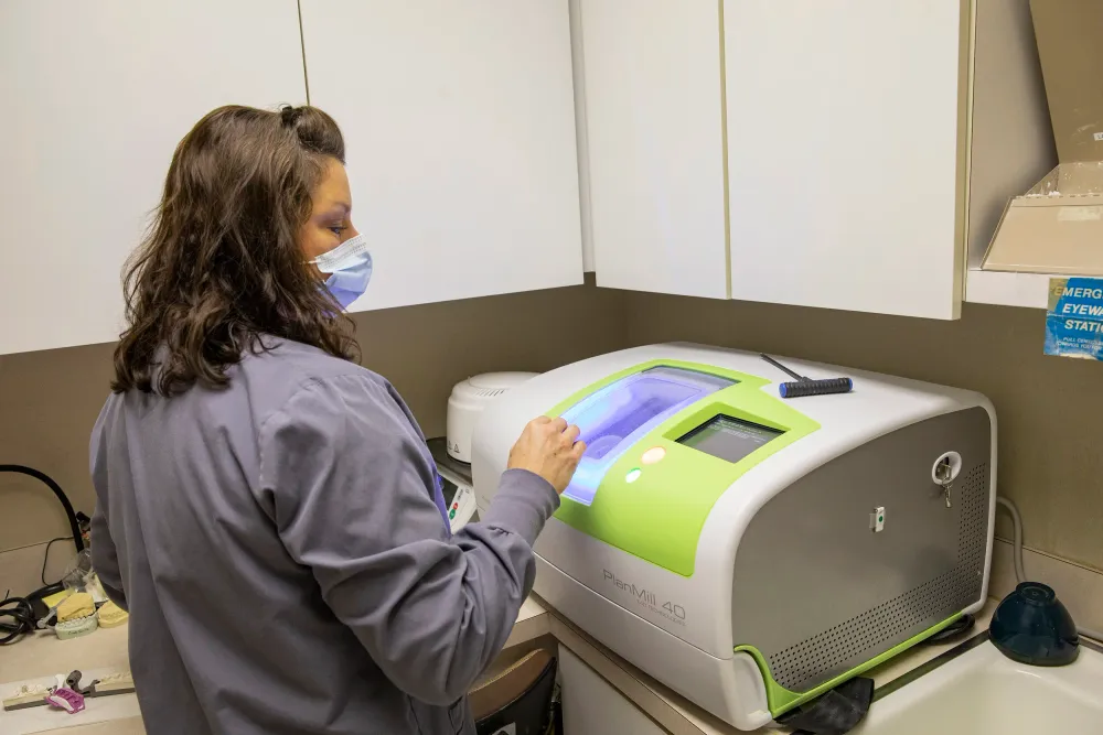 Dental professional operating an in-house PlanMill 40 milling machine.