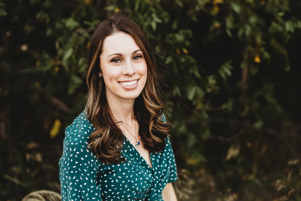 Dr. Jordan Pittman &mdash; outdoor portrait in a green speckled dress.