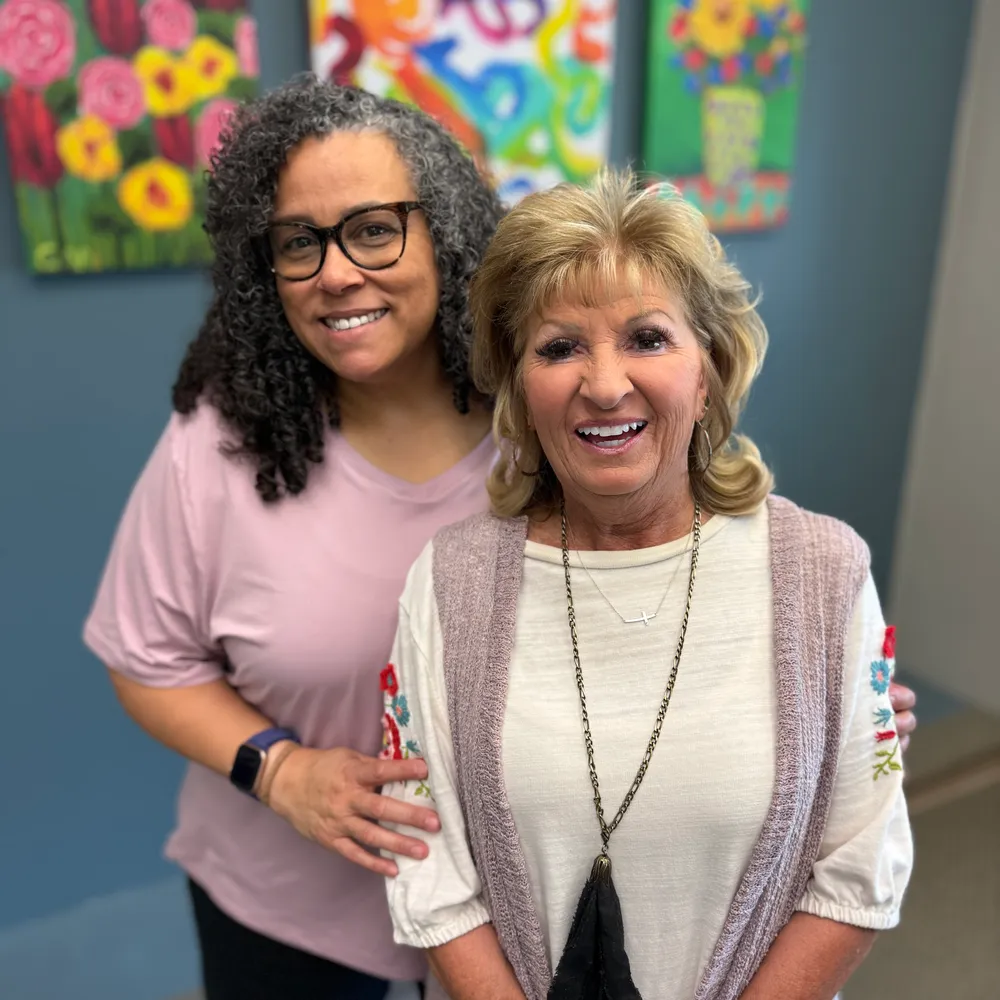 Two Cornerstone team members smiling together in the office.